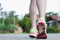 Runner woman feet running on road closeup on shoe. Female fitness athlete jogger workout in wellness concept at sunrise. Sports