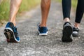 Runner woman and man feet running on road closeup on shoe. Sports healthy lifestyle concept Royalty Free Stock Photo