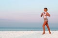 Runner woman running in the beach at sunset. Royalty Free Stock Photo