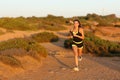 Runner woman running in the mountain towards camera