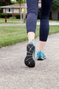 Runner/ woman running on a road, closeup on shoe/sneakers. Royalty Free Stock Photo