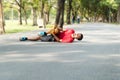 Runners catch knee from accident in public park. Injury from run. Man wearing red shirt lying on the road inside the Park Royalty Free Stock Photo