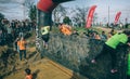 Runners climbing wall in a test of extreme obstacle race