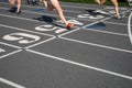 Runners cross the numbered finish line of an athletic track Royalty Free Stock Photo