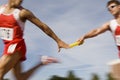 Runners Passing Baton In Relay Race Royalty Free Stock Photo