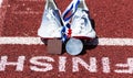 Runners racing spikes with medals at Finish Line