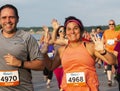 Runners smiling and waving while racing on a boardwalk in the New York State Summer Series