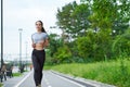 Running asian woman on the waterfront. Morning jogging. The athlete trains