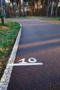 Running asphalt track in the forest with a mark of 10 meters. Royalty Free Stock Photo