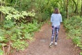 Running athlete behind rear view woman walking exercise healthy lifestyle concept in wooden pathway forest park