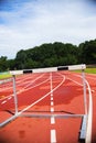 Running athletic track with hurdle, bad weather, wet