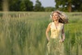 Running blonde girl on the field. Life in the country