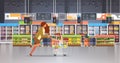 Running business woman customer with shopping trolley cart busy female shopper buying products grocery market interior