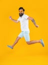 running caucasian stylish guy in studio isolated on yellow background