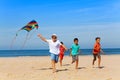 Group of children run on the beach with color kite Royalty Free Stock Photo