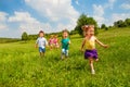 Running children in green field during summer