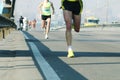 Running on city road. Marathon running in the morning light . Athlete runner feet running. Young runners running on city bridge