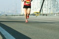 Running on city road. Marathon running in the morning light. Young man running on city bridge road. Athlete runner feet. Blured