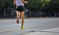 Running in the city roads. Young man runner, back view, blur background, copy space Royalty Free Stock Photo