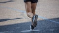 Running in the city roads. Young man runner, back view, blur background, copy space Royalty Free Stock Photo