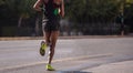 Running in the city roads. Young woman runner, back view, blur background Royalty Free Stock Photo