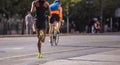 Running in the city roads. Young woman runner, back view, blur background Royalty Free Stock Photo