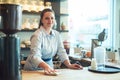 Running a coffee shop requires lots of hard work. Portrait of a young woman cleaning a countertop in her cafe. Royalty Free Stock Photo