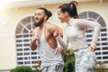 Running couple training outdoors working out against fitness centre.