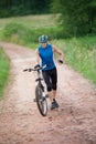 Running cyclist pushing his bicycle