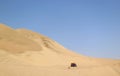 Running dune buggy chasing by a naughty dog on the sand dunes of Huacachina desert, Ica region, Peru Royalty Free Stock Photo