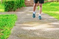 Running feet male in runner jogging exercise with old shoes for health lose weight concept on concrete road public park