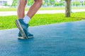 running feet male in runner jogging exercise with old shoes for health lose weight concept on track rubber cover blue public park Royalty Free Stock Photo