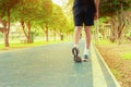Running feet male in runner jogging exercise with old shoes for health lose weight concept on track rubber cover blue public park Royalty Free Stock Photo
