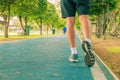 Running feet male in runner jogging exercise with old shoes for health lose weight concept on track rubber cover blue public park Royalty Free Stock Photo