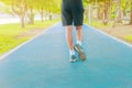 Running feet male in runner jogging exercise with old shoes for health lose weight concept on track rubber cover blue public park Royalty Free Stock Photo