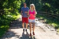 Running fitness couple of runners doing sport on road outdoor. Active living man and woman jogging training cardio Royalty Free Stock Photo