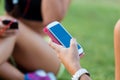 Running girls having fun in the park with mobile phone. Royalty Free Stock Photo