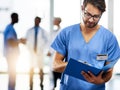 Running through his doctoring duties for the day. a young doctor reading the contents of a file with his colleagues in