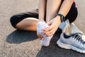 Running injury leg accident- sport woman runner hurting holding painful sprained ankle in pain. Female athlete with joint or Royalty Free Stock Photo