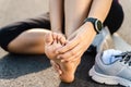 Running injury leg accident- sport woman runner hurting holding painful sprained ankle in pain. Female athlete with joint or Royalty Free Stock Photo