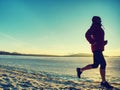 Running or jogging on beach in winter, sunny day morning