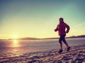 Running or jogging on beach in winter, sunny day morning