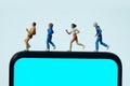 Running and jogging tracking app concept. A family running above smartphone. Miniature people figure photography