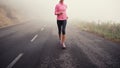 Running, legs and woman on road outdoor in forest, park or woods for exercise in winter. Morning, fog and person with Royalty Free Stock Photo