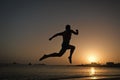 Running man. silhouette of running man on sunset fiery sky background in sea, sport and recreation, future and success Royalty Free Stock Photo