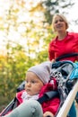 Running mother with stroller enjoying motherhood in autumn