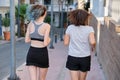 Running mother and teenage daughter, back view