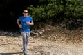 Running muscular man athlete runner training outdoor in forest. Running runner sportsmen wearing sportswear in cross country. Royalty Free Stock Photo