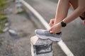 Running shoes. close up female athlete tying laces for jogging on road. Runner ties getting ready for training. Sport Royalty Free Stock Photo