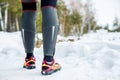 Running shoes - closeup of female sport fitness runner getting ready for jogging outdoors in winter Royalty Free Stock Photo